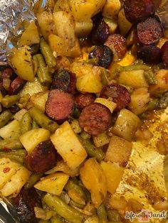 potatoes, green beans and sausage are cooked in tinfoil on the stove top with seasoning