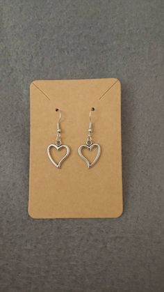 Silver plated open heart dangle earrings on hypoallergenic hook. Nickel free Trendy Heart Charm Earrings For Mother's Day, Trendy Open Heart Earrings For Gift, Metal Heart Earrings For Mother's Day, Trendy Nickel-free Earrings For Mother's Day, Mother's Day Metal Heart Earrings, Mother's Day Heart Shaped Metal Earrings, Mother's Day Heart-shaped Metal Earrings, Trendy Dangle Heart Earrings With Ear Wire, Trendy Sterling Silver Heart Earrings For Everyday