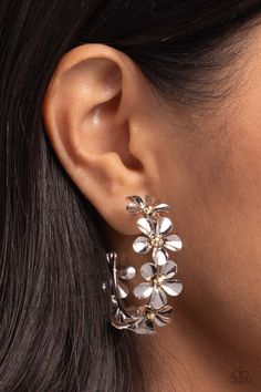 Featuring gold bead centers, metallic silver flowers whimsically curl around the ear for a neutral floral display. Earring attaches to a standard post fitting. Hoop measures approximately 1 1/2" in diameter.   Sold as one pair of hoop earrings. Elegant Flower-shaped Metal Hoop Earrings, Elegant Flower Shaped Metal Hoop Earrings, Elegant Metal Flower Hoop Earrings, Silver Metal Flower Earrings For Spring, Silver Flower Metal Earrings For Spring, Spring Silver Flower Metal Earrings, Spring Silver Metal Flower Earrings, Flower Shaped Metal Jewelry For Spring, Floral Metal Jewelry For Spring