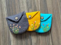 three small purses sitting on top of a wooden floor