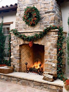 an outdoor fireplace with wreaths on it