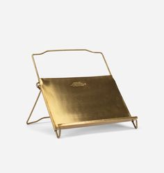 a gold tray with handles on the top and bottom, sitting in front of a white background