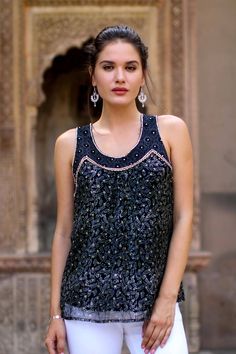 Capturing the glory of midnight, this black viscose tank top is decorated with intricate floral motifs using the traditional block-printing technique. India's Vijay Singh presents this elegant sleeveless top, which has hand beading accenting the neckline. Black Festive Tops For Summer, Elegant Sleeveless Tank Top For Festive Occasions, Festive Black Sleeveless Blouse, Sleeveless Top With Mirror Work For Festive Occasion, Sleeveless Tops With Mirror Work For Festive, Bohemian Black Tank Top, Bohemian Sleeveless Top For Festive Occasions, Elegant Sleeveless Top With Mirror Work, Black Festive Blouse For Summer