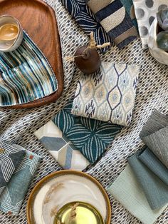 a table topped with plates and napkins covered in different colored cloths next to a cup of coffee