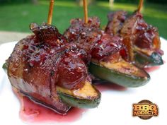 bacon wrapped jalapenos are sitting on a plate with toothpicks sticking out of them