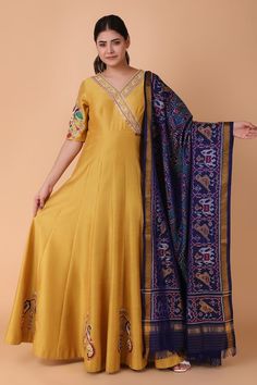 Mustard yellow floor length anarkali with placement floral, twin peacock motif embroidery using pearl, sequins. Paired with a blue dupatta with all over ikat pattern, cutdana and gota patti. - Aza Fashions Yellow Anarkali Dress With Cutdana, Yellow Anarkali Dress With Cutdana Detailing, Yellow Cutdana Anarkali Dress, Traditional Yellow Maxi Length Gown, Transitional Yellow Dress With Resham Embroidery, Yellow Maxi Length Sets For Festive Occasion, Yellow Festive Maxi Length Set, Yellow Maxi Length Festive Set, Yellow Anarkali Gown With Dabka Work