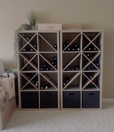 two shelving units with wine bottles in them on carpeted floor next to boxes