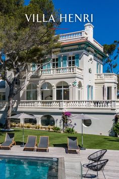 a large white house sitting next to a swimming pool