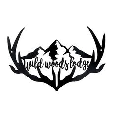 a metal sign that says wild woods lodge with antlers and mountains in the background