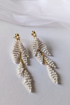 Delicate, Handmade ALAYA Wedding Earrings Dreaming of unique jewelry for your wedding? Our handmade earrings are the perfect choice!  Crafted from high-quality materials: gold-plated wire, pearly seed beads, and hypoallergenic stainless steel studs, they will enchant you with their delicate beauty.  Thanks to the two-part design, you can wear them both long and short, adapting them to any style. Ideal for weddings, but also for many other occasions. Earrings measurement: * Full length: approx 8cm (3.15") * Short part length: approx 3.3cm (1.3") Matching Items:   See Other EARRINGS: https://www.etsy.com/shop/martalilyjewellery/?etsrc=sdt&fbclid=PAZXh0bgNhZW0CMTEAAabSJ6QrVgLVFeGJhsEoqw9viOlBSQ6EGWor-p_Zyv4UQ0idJ2NciFsHfdg_aem_SD41An-A-HJk9DPh-CSeDQ&section_id=40157901 CARING FOR GOLD-PLATED Beaded Wedding Earrings, Minimalist Wedding Earrings, Wedding Drop Earrings, Wedding Earrings Drop, Delicate Beauty, Beaded Wedding, Earrings Minimalist, Stunning Earrings, Minimalist Wedding