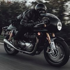 a man riding on the back of a black motorcycle