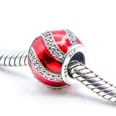 Authentic Pandora Adornment Sterling Silver Charm With Red Enamel And Clear Zirconia 791991EN07 - Retired. A bright red hue and a striking stone-studded ribbon embellishment gives this sterling silver charm a lavish expression. Red is the color of passion and draws attention like no other, radiating a strong and powerful energy that invokes us to take action. A beautiful touch for a Christmas themed bracelet too. This item is retired from production and may be difficult to find. Charm is pre-own Luxury Red Rhinestone Jewelry, Luxury Red Jewelry With Sparkling Stones, Red Sparkly Jewelry For Formal Occasions, Red Rhinestone Jewelry For Valentine's Day, Red Rhinestone Jewelry Gift, Red Rhinestones Jewelry For Valentine's Day, Red Rhinestone Jewelry For Anniversary, Red Embellished Party Jewelry, Red Jeweled Cubic Zirconia Jewelry