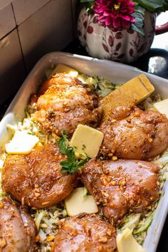 a pan filled with chicken and rice covered in parmesan cheese next to a potted plant