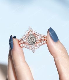 a woman's hand holding an engagement ring with diamonds and pearls on the band