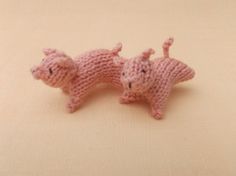 two pink knitted animals laying on top of a table