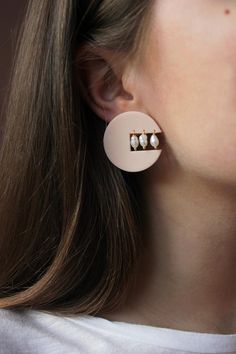 a close up of a person wearing some kind of earring with pearls on it