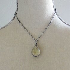 "A lovely glass locket is the focal of this choker style necklace. The teardrop shaped locket is made of translucent pale green glass encased in sterling silver. It has a swivel bail so the contents can be seen from either side. The locket is gorgeous by itself, but does open at the top so that you can place your treasures inside. A piece of lace, a feather, or your favorite photos will be kept secure with a screw closure. The pendant sways from a chunky silver link chain. The textured sterling Silver Teardrop Glass Necklaces, Spiritual Teardrop Locket Necklaces, Spiritual Teardrop Locket Necklace, Vintage Teardrop Drop Necklace, Vintage Drop Necklace For Gift, Unique Teardrop Necklace With Lobster Clasp, Push Gifts, Push Present, Silver Link Chain