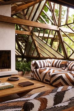 a living room filled with furniture and a fire place in front of a wooden ceiling