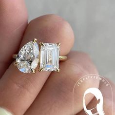 a woman's hand holding an engagement ring with three stones on the side and one stone in the middle