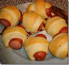 several hotdogs wrapped in bread on a plate