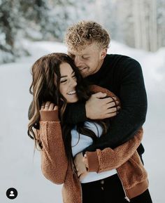 a man and woman hugging in the snow