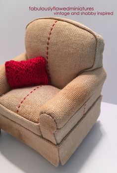 a small chair with a red pillow on it's back and the seat is made out of burlap