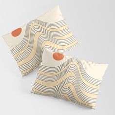 two pillows with an orange dot on them