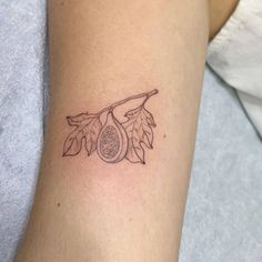 a tattoo on the arm of a woman with leaves and an acorn in it