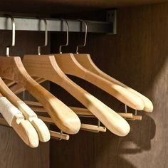 wooden clothes hangers in a closet with metal hooks