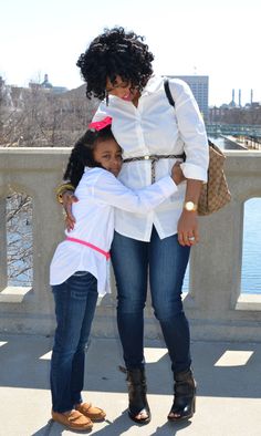 two women standing next to each other on a bridge