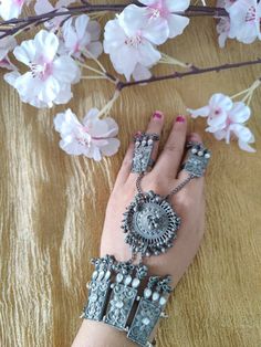 This beautiful oxidized Haath Phool is a part of Indian bridal jewelry. This Indian ethnic Haath Phool comes with an attached adjustable Ring Haatphools are back in fashion after a very long time and have returned with a bang. This piece of oxidised black polish haathphool consists of a bracelet & a rink which is joined by chains. This gives off a very elegant & royal look if you pair it up with any outfit. We generally see brides wearing haatphool & this piece of Indian jewelry is very occasion Bohemian Alloy Bangle Jewelry, Bohemian Alloy Bangle, Festival Alloy Bracelet Jewelry, Elegant Festival Alloy Bracelets, Silver Alloy Bracelets For Festival, Bohemian Alloy Bracelets For Festivals, Alloy Bangle For Wedding, Wedding Alloy Bangle Jewelry, Heavy Metal Bracelet For Festival