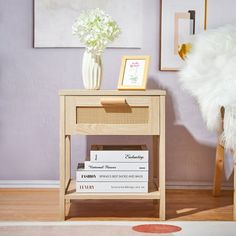 a table with some books on it and a vase full of flowers next to it