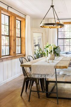 a dining room table with chairs and a chandelier hanging from it's ceiling