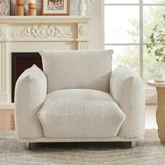 a living room with a white chair and fireplace