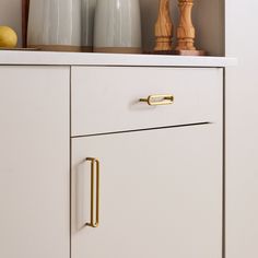 a white cabinet with gold handles and knobs