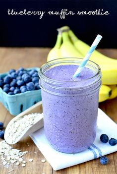 a blueberry muffin smoothie in a mason jar next to bananas and blueberries