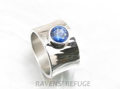 a silver ring with a blue stone on it