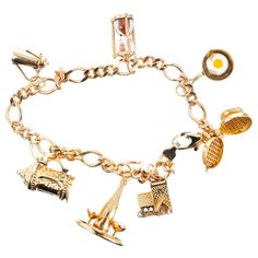 Figaro style 14k yellow gold charm bracelet. Food and drink motif charm bracelet consists of seven charms. A waffle iron, frying pan with egg, sand timer, carafe stein, champagne bottle and glasses and a tavern all in 14k yellow gold. 7.75 inches long. 14k yellow gold Stamped: 14k 24.7 grams Bracelet: 7.75 Inches Gold Charm Bracelet Gift, Cheap Gold Charm Bracelets, Luxury Gold Round Charm Bracelet, Cheap Yellow Charm Bracelet For Gift, Luxury Vintage Charm Bracelet, Luxury Yellow Gold Fine Jewelry Charm Bracelet, Sand Timer, Sand Timers, Jewelry Words