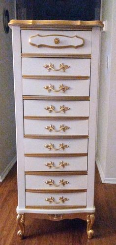 a white and gold chest of drawers in a room