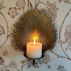 a lit candle sitting on top of a wall