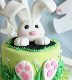 a cake decorated with green icing and white frosting has an image of a bunny in the grass