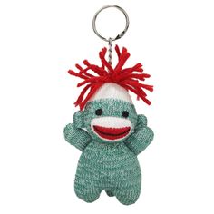 a knitted monkey keychain with a red mohawk on it's head