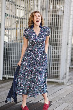 a woman laughing while walking on a wooden deck