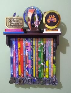 there is a shelf with many different items on it, including books and medals hanging from the wall