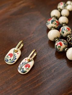 Add a touch of Ukrainian charm to your wardrobe with our exquisite jewelry set! Handcrafted by Oksana Boriychuk, this set includes a bead necklace and hand-painted earrings, each adorned with unique designs. Ideal for gifting on special occasions like birthdays or Mother's Day, this set is sure to delight any woman in your life. #UkraineJewelry #BeadNecklace Traditional Flower-shaped Jewelry With Ear Wire, Artist Jewelry, Jewelry Holiday, Indie Jewelry, Hand Painted Earrings, Minimalist Women, Painted Earrings, Ceramic Earring, Royal Jewelry