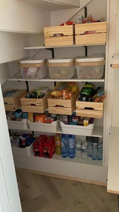 an organized pantry with bins and baskets on the bottom shelf, full of food