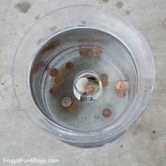 a glass bowl filled with lots of coins