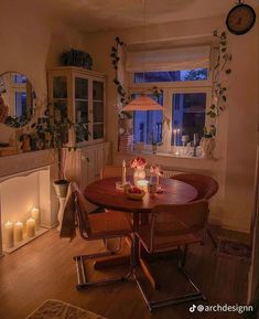 a dining room table with candles on it in front of a window and a fireplace