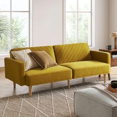 a living room scene with focus on the yellow couch and pillows in the foreground