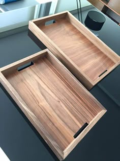 two wooden trays sitting on top of a table